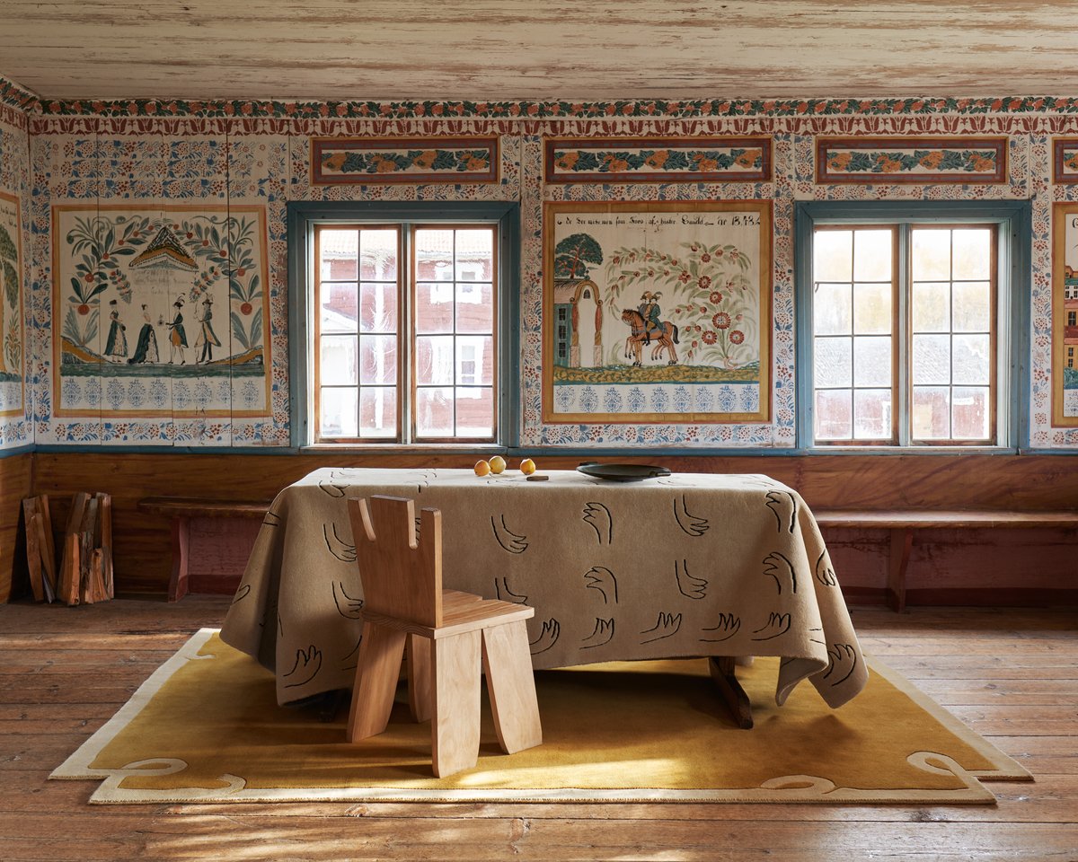 Loops – Yellow sets a warm foundation in this historic space, its soft curves complementing the handcrafted charm of painted walls. Draped over the table, All Hands – Beige adds a graphic, modern contrast with its playful hand motif.