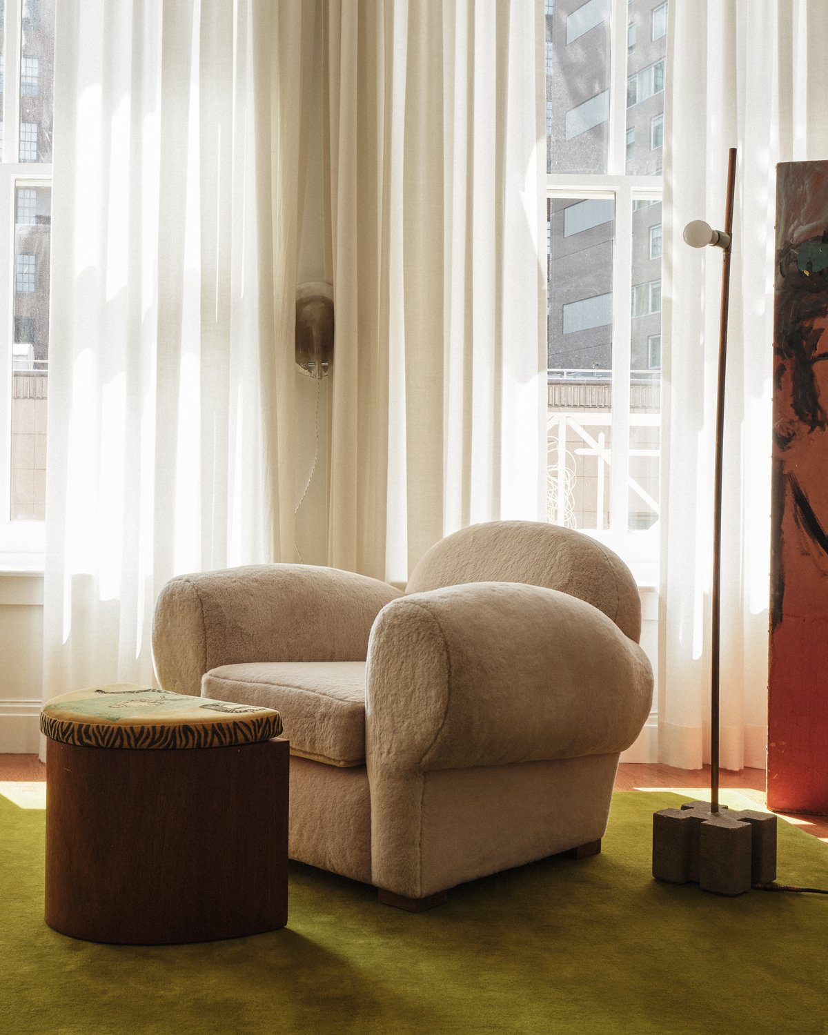 Tapis en laine moelleux Grand en couleur Milano Green présenté dans un salon avec un fauteuil doux et des détails d’intérieur artistiques à New York.