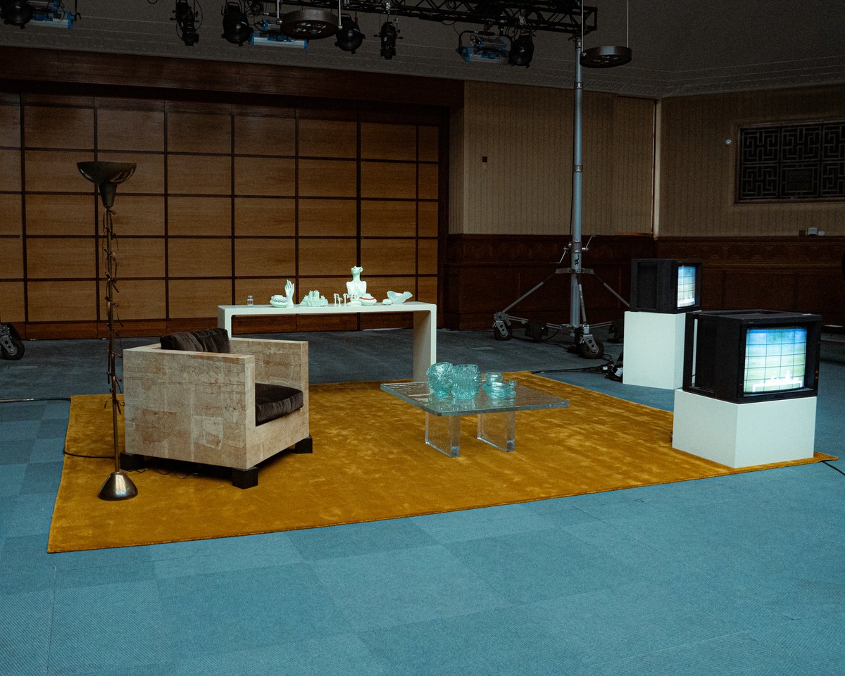 Grand rug in Leo displayed during London Fashion Week in a curated space by interior designer Hollie Bowden, featuring the rug with a sand-colored armchair and glass table.