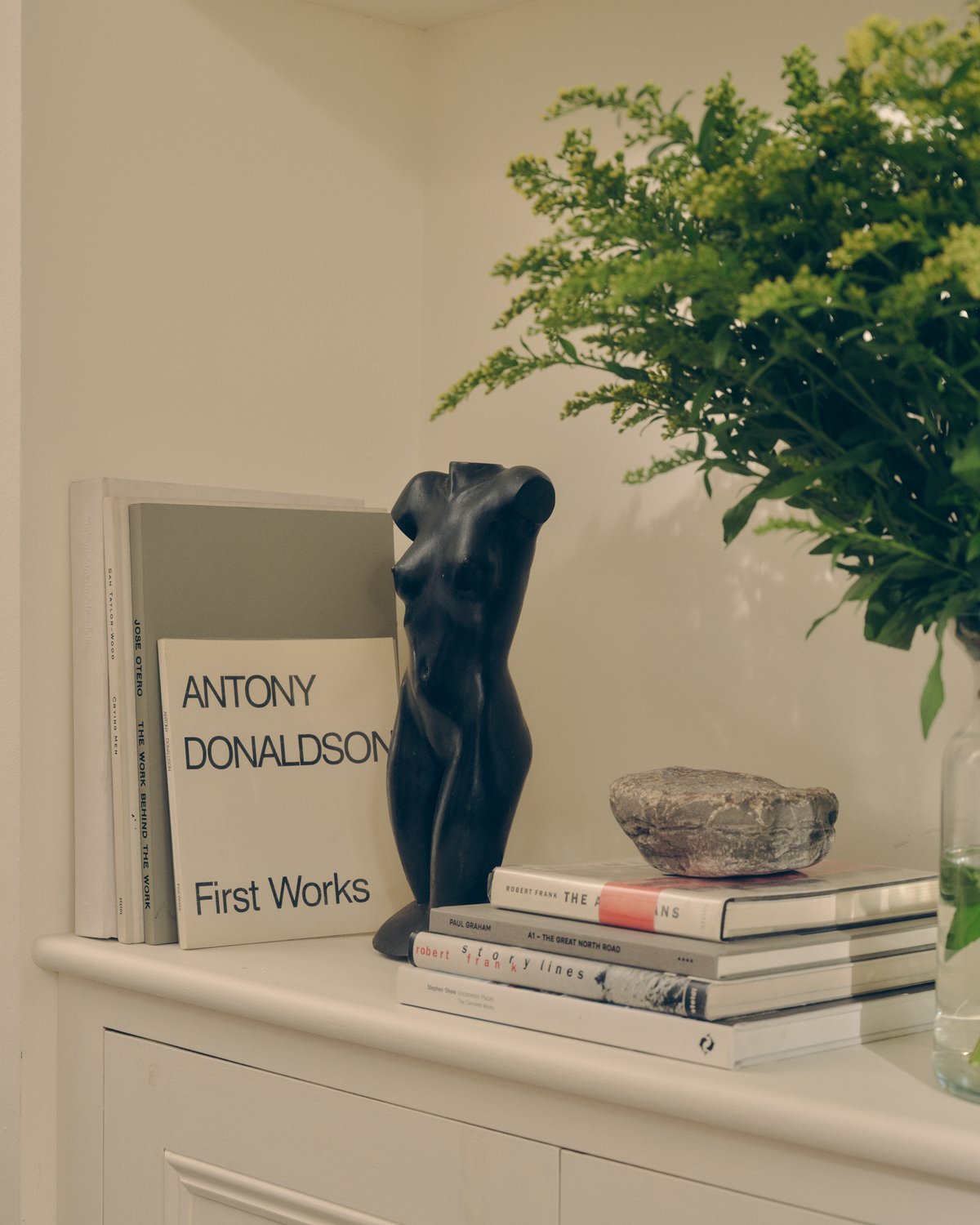 Gros plan sur des livres et une statue de corps féminin.