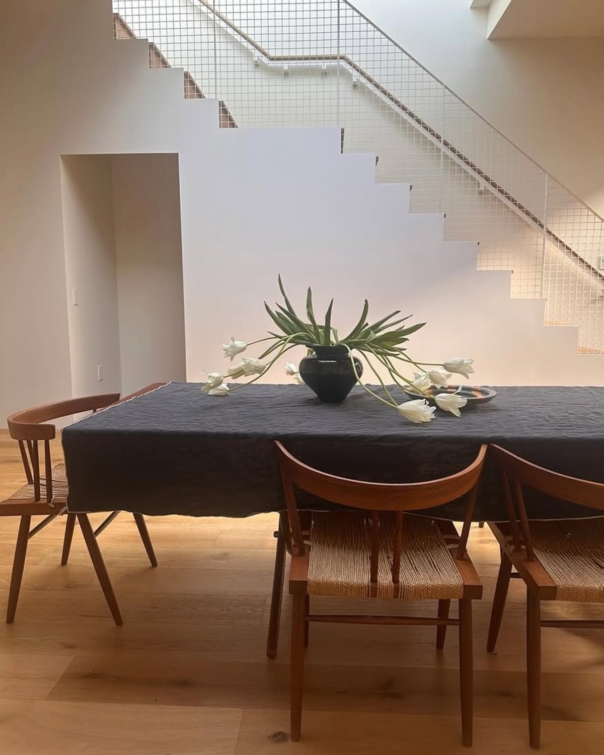Une belle composition florale posée sur une table à manger dans une salle à manger lumineuse.