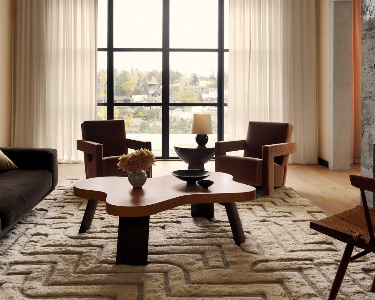 Boho 02 in Shearling, photographed in a bright living room beneath a sculptural coffee table and lounge chairs by a large window.