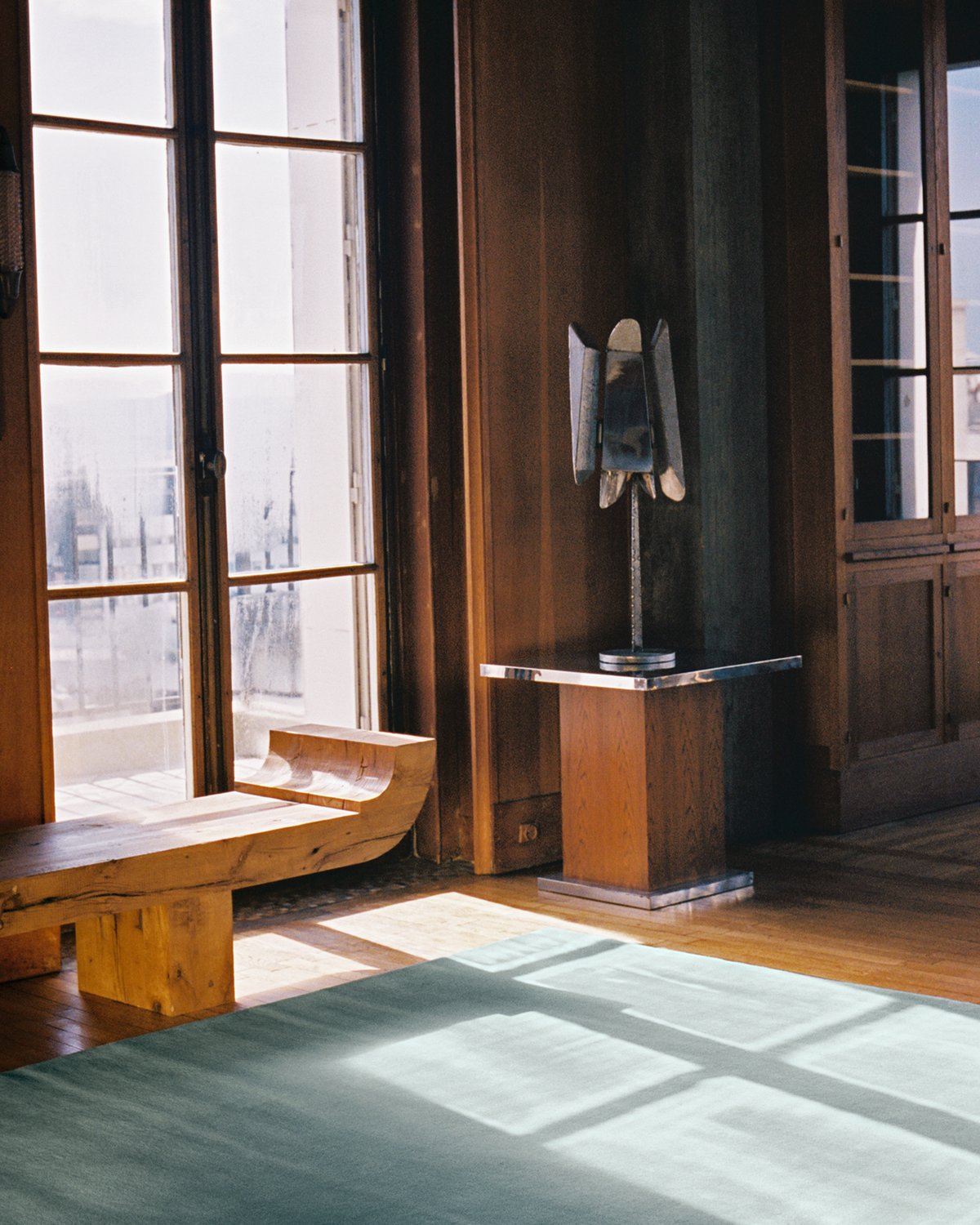 Tapis en laine moelleux Grand Pale Green, photographié dans un bel appartement parisien avec des détails d’intérieur en bois et de grandes fenêtres.