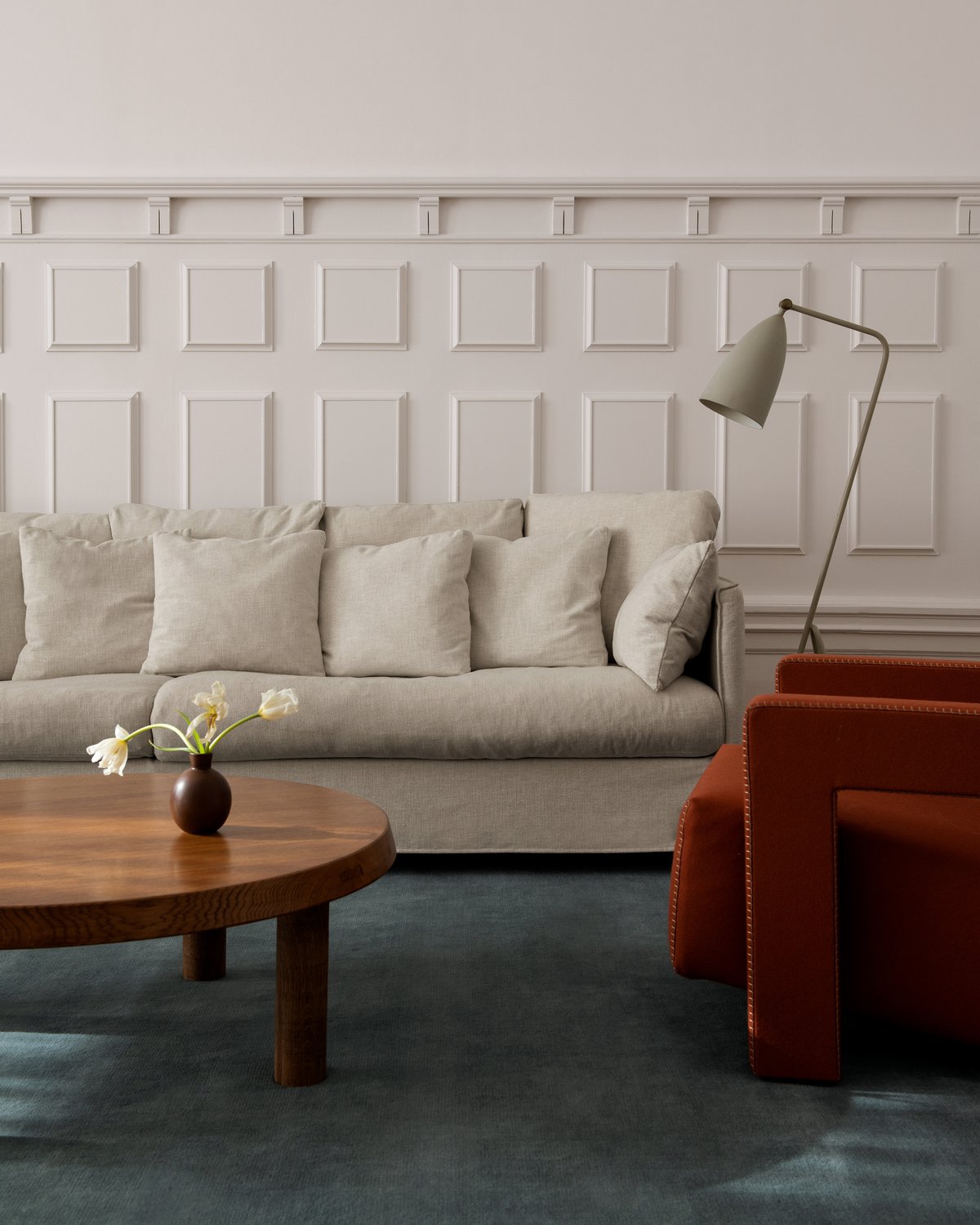 Flauschiger Wollteppich Grand in der Farbe Pale Sand, präsentiert in einem minimalistischen Wohnzimmer.