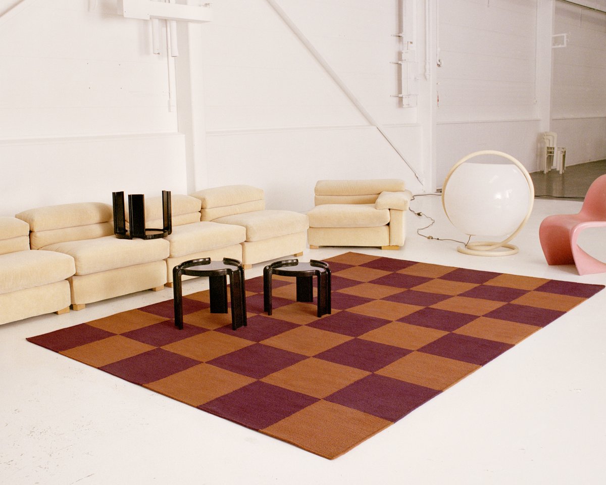 Industrial warehouse setting with modern furniture and Square Red/Orange rug. Shot in Amsterdam.