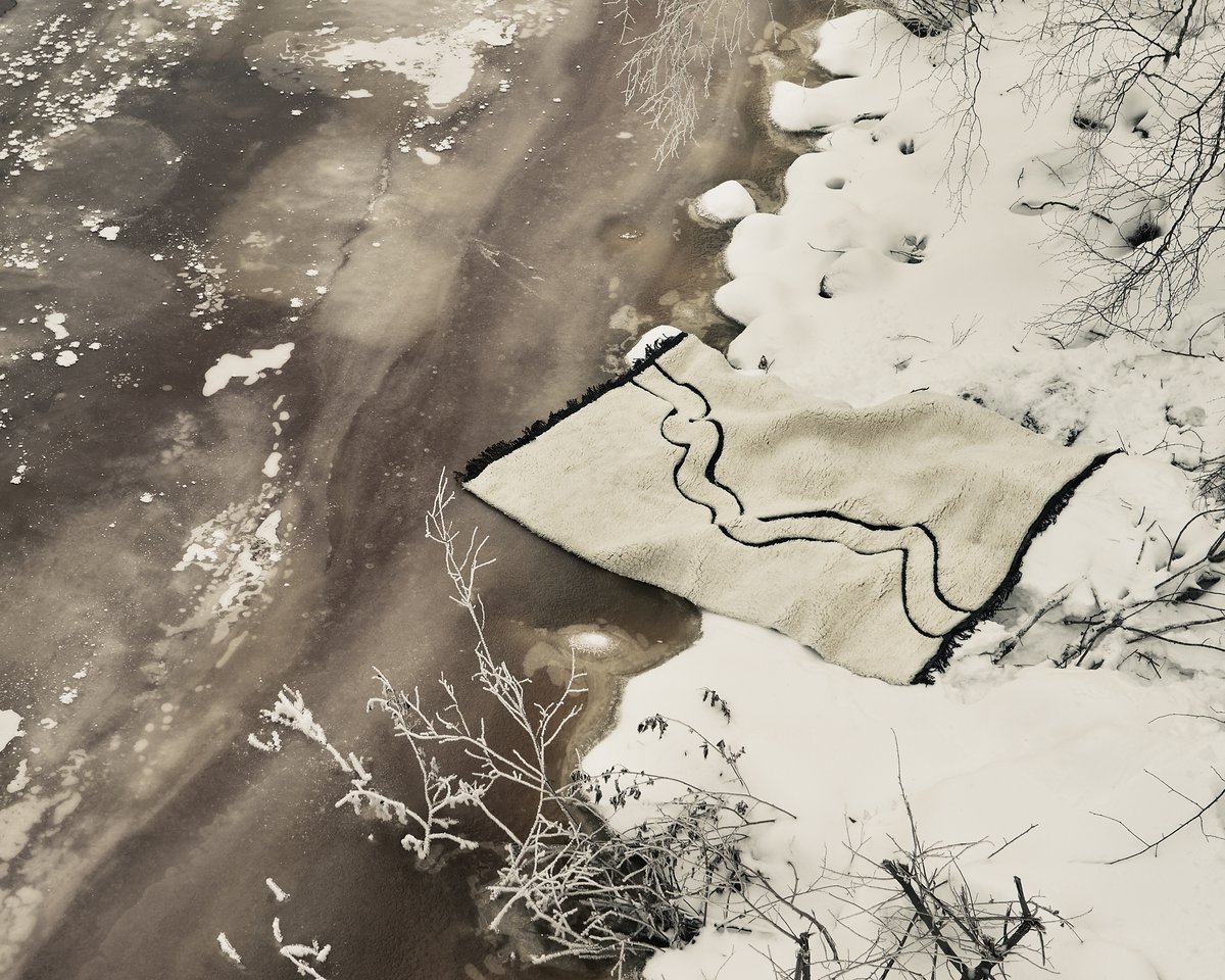 River – Mud White entfaltet stillen Kontrast vor einer gefrorenen nordischen Landschaft. Die handgezeichnete Linie und die organische Textur spiegeln den Rhythmus der Natur wider – weich, skulptural und in Ruhe verwurzelt.