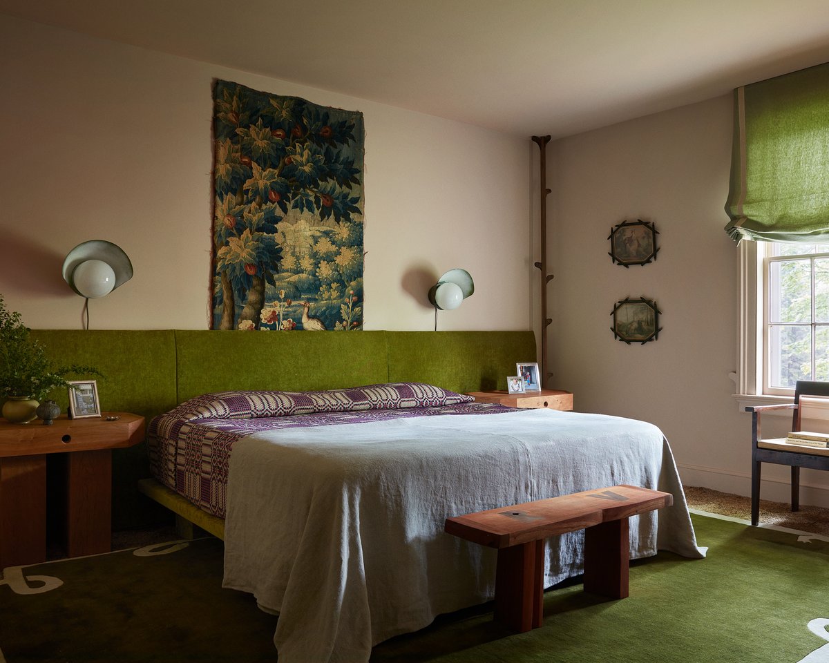 Flauschiger Wollteppich Loops in Green, abgebildet in einem eklektischen Schlafzimmer mit grünem Bettrahmen, Vorhang und Wandteppich.